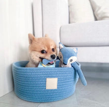 Load image into Gallery viewer, Small dog lying comfortably in the FuzzYard Life French Blue Rope Basket Bed with reversible cushion.
