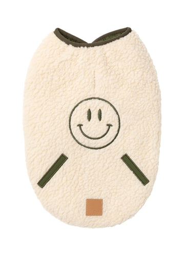 Beige sherpa dog jacket with embroidered green smiley face and quilted sage trims.